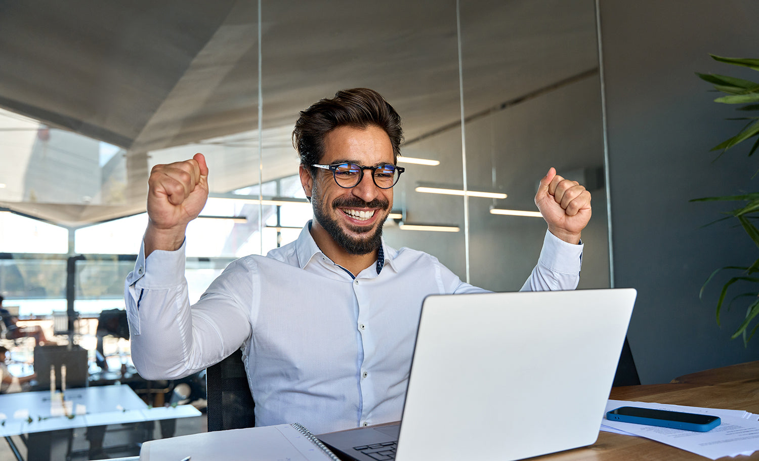 man cheering in front of a computer