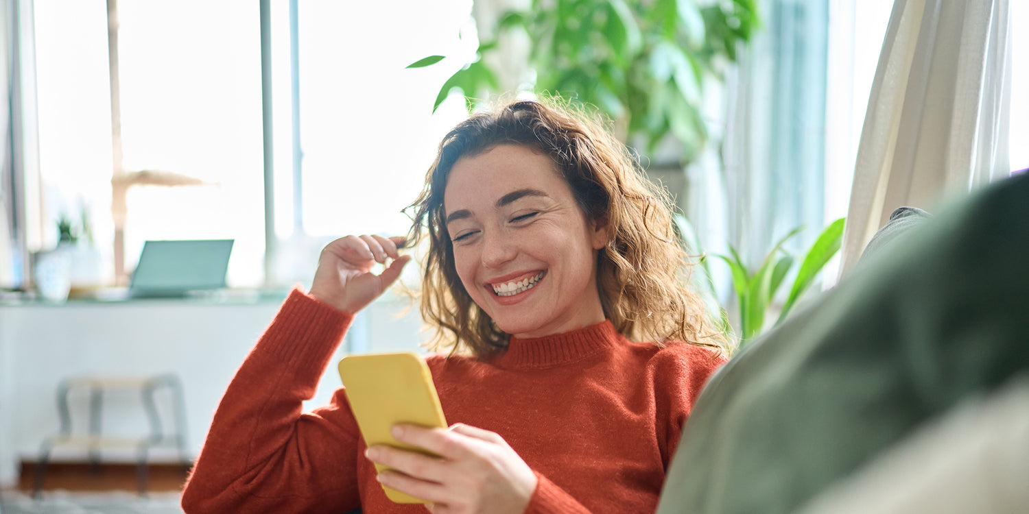 woman smiling looking at her Apple iPhone